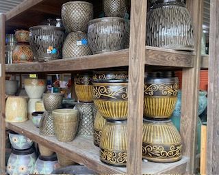 Shelves of decorative ceramic planters and vases in assorted colors and patterns in a shop.