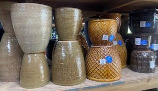 Shelves of woven storage baskets and dark glass jars in a store display