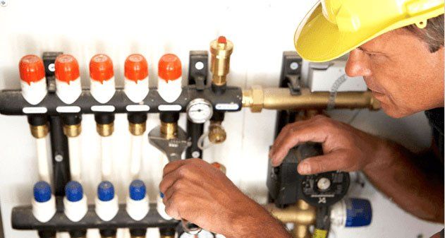 Plumber fixing water pipes, Plumber checking water pressure gage