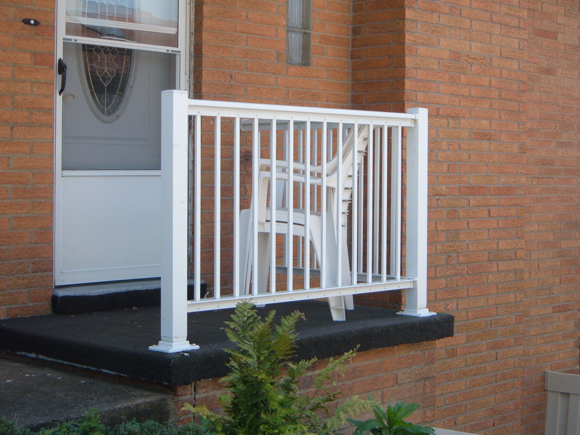 White wheelchair ramp and railing outside a brick building doorway