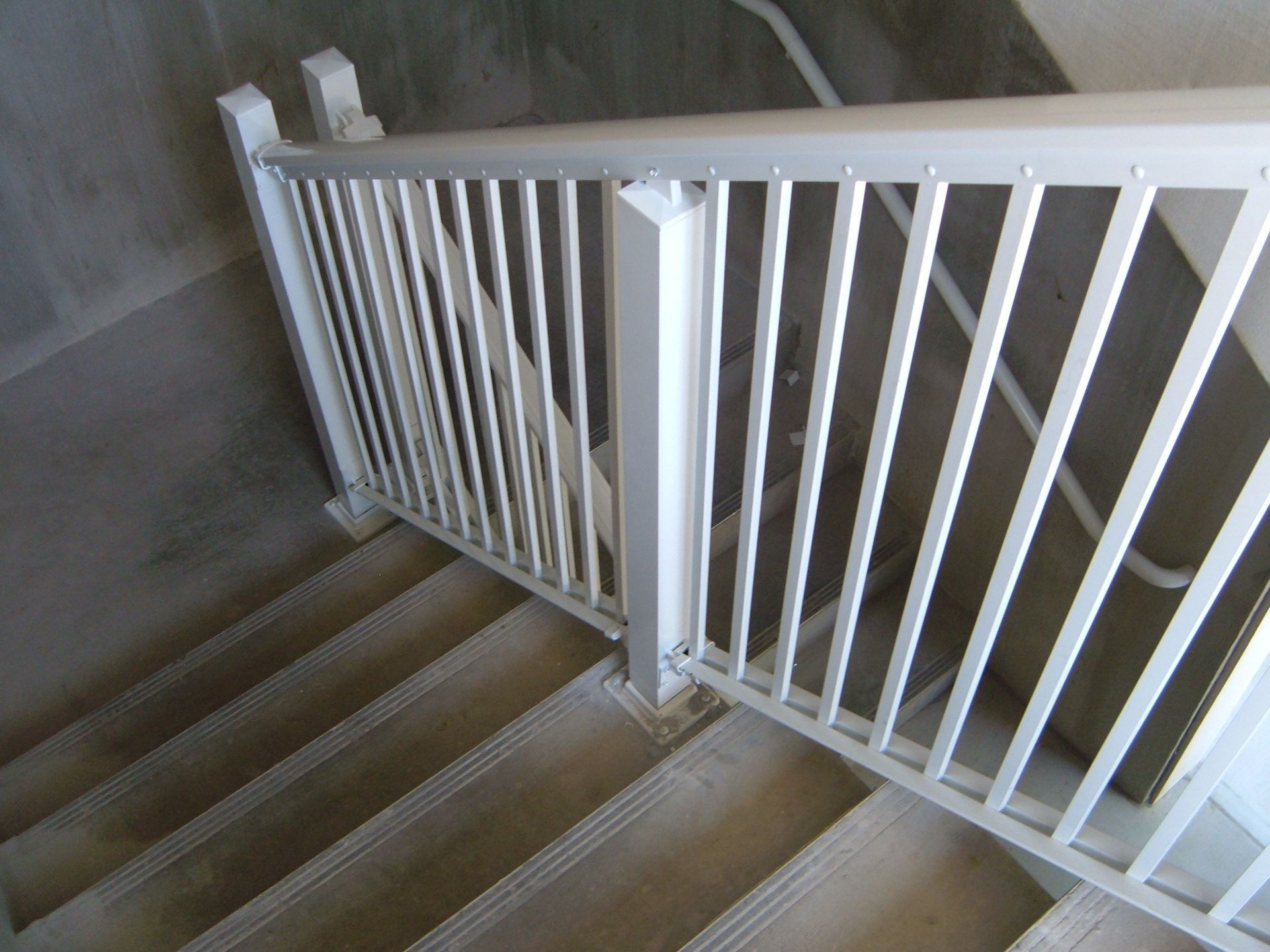 White stair gate blocking the top of a carpeted staircase