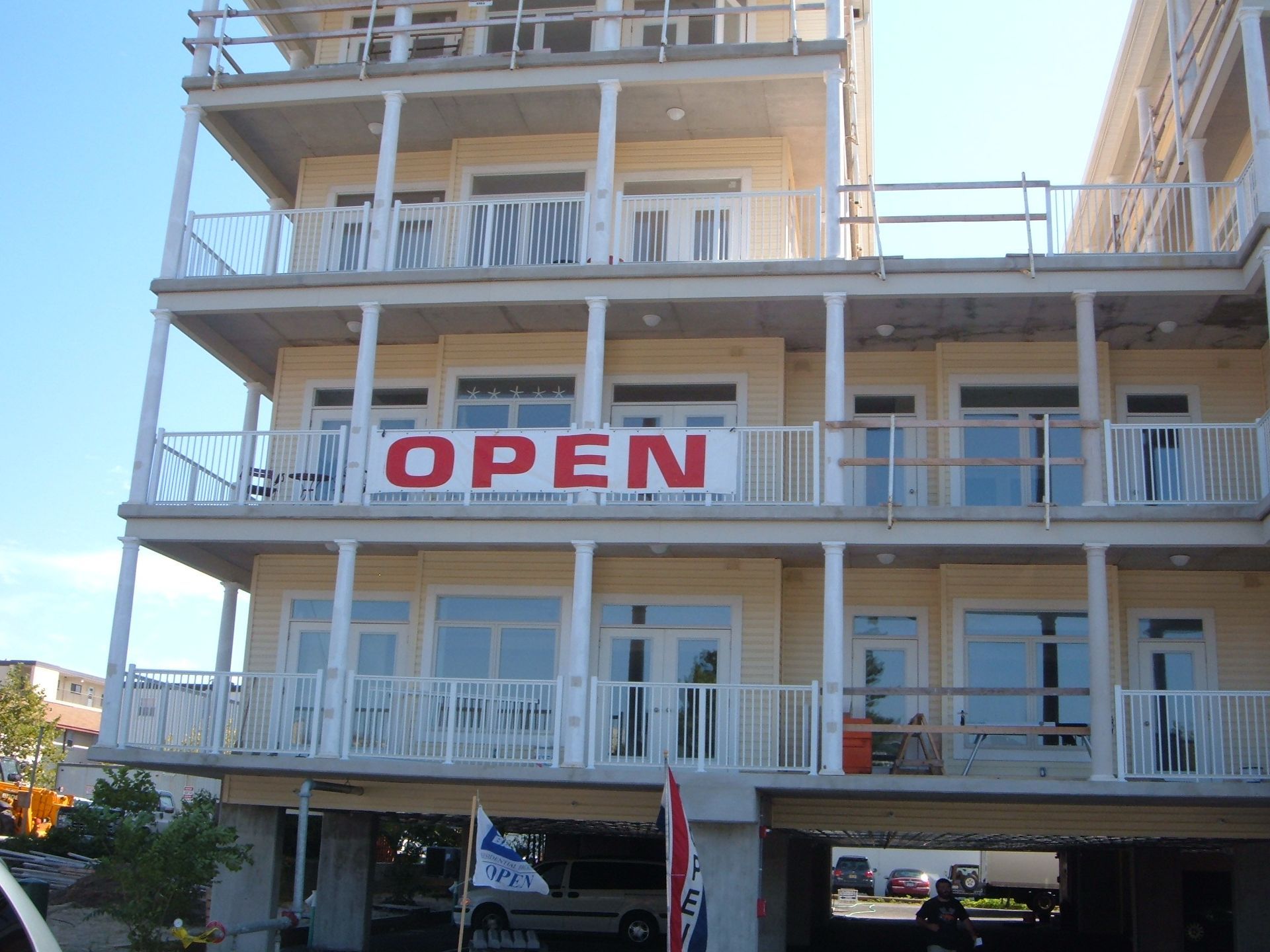 Three-story building with balconies and a large red OPEN banner