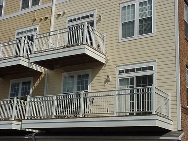 Two-story beige apartment building with balconies and white railings