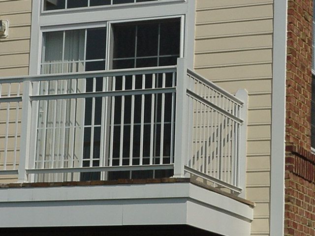 Apartment balcony with gray railing and sliding glass door