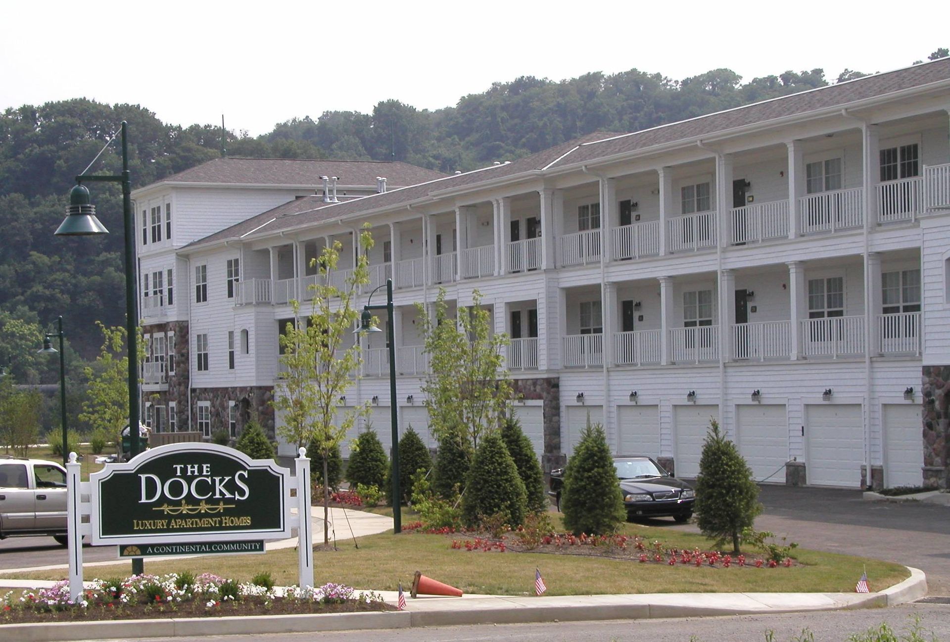 The Docks sign in front of a white waterfront hotel building and parking lot.