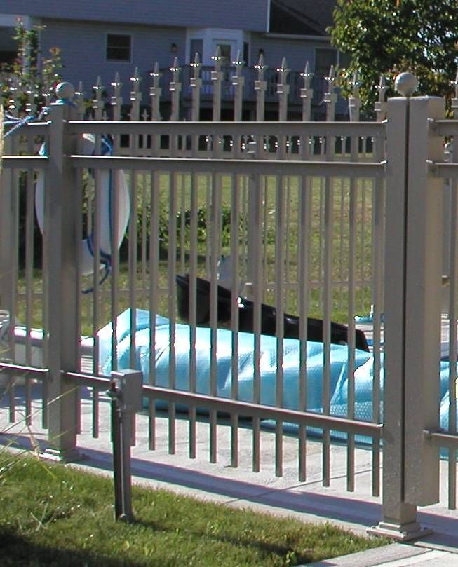 Blue kayak behind a metal fence in a grassy yard