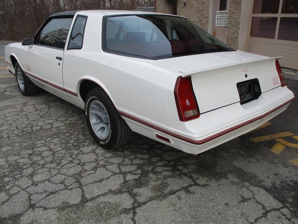 A white car is parked in a parking lot
