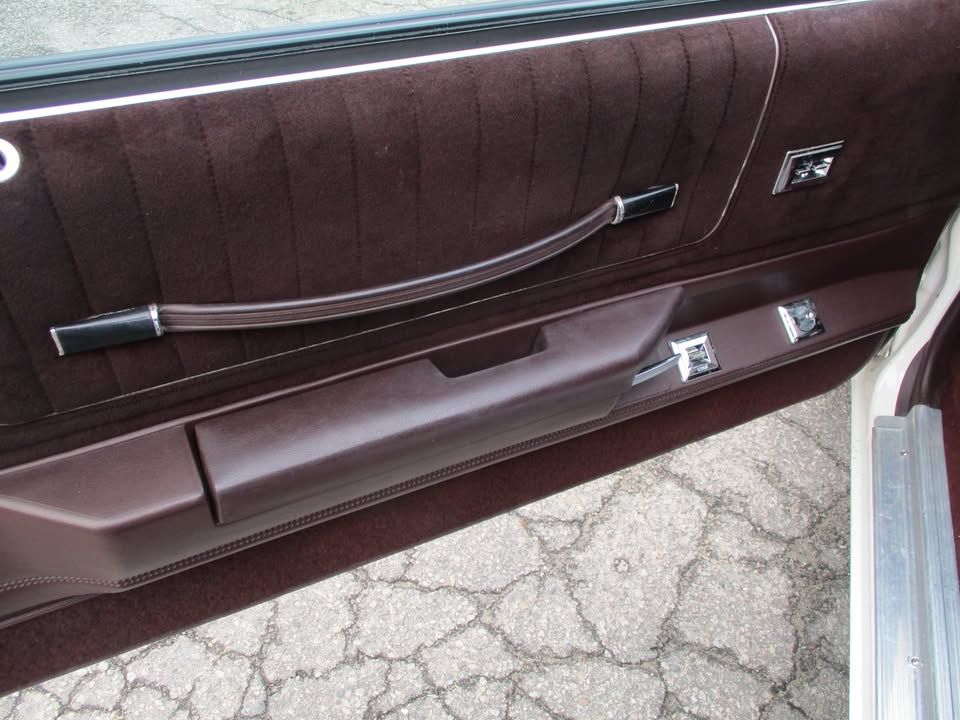 A close up of a car door with a black handle