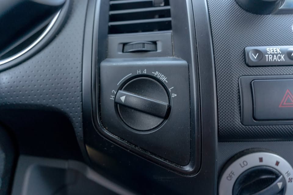 A close up of a car dashboard with a steering wheel and a shifter.