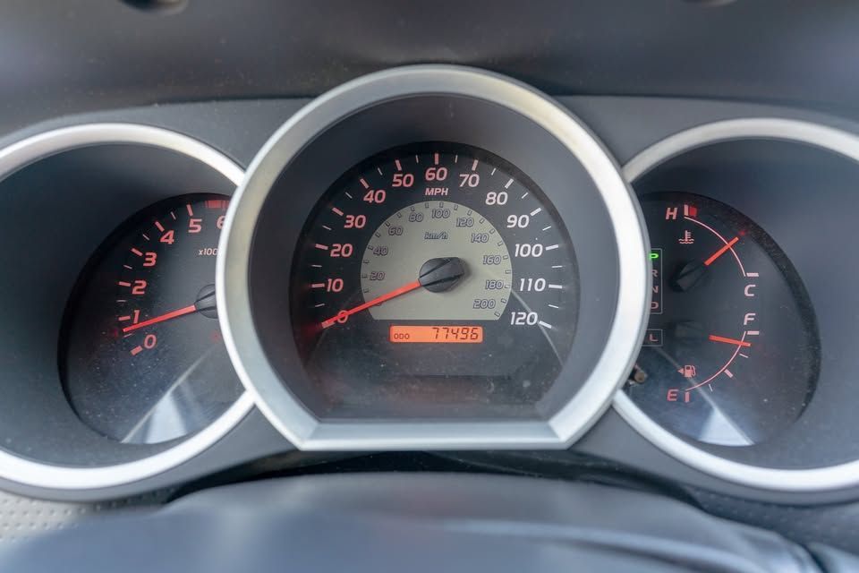 A close up of a car dashboard with a speedometer and a tachometer.
