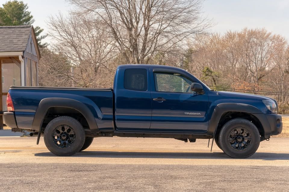 A blue pickup truck is parked in front of a house.