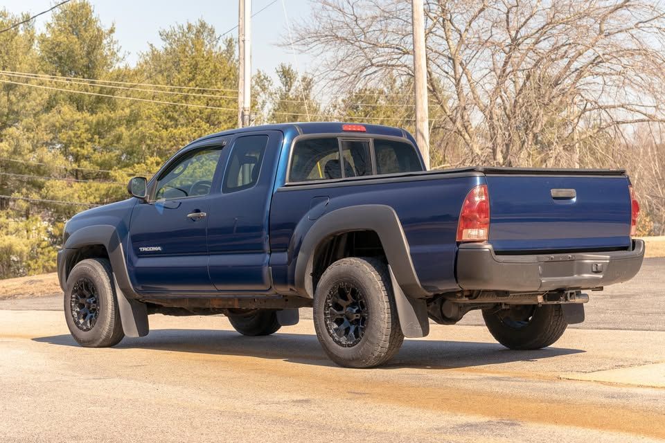 A blue toyota tacoma truck is parked in a parking lot.