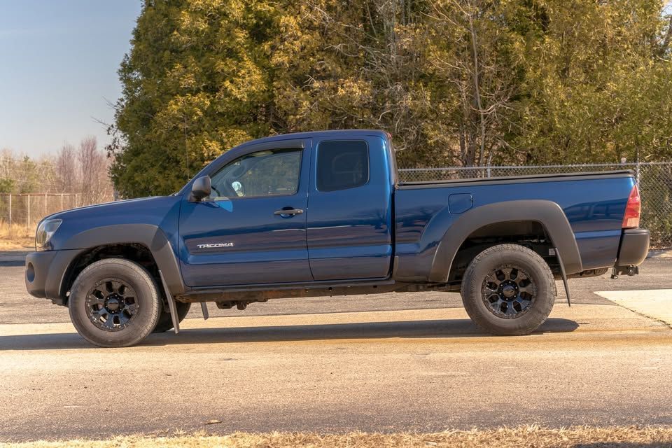 A blue pickup truck is parked on the side of the road.