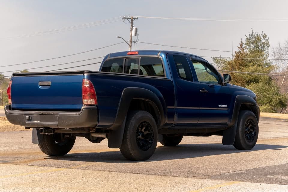A blue truck is parked on the side of the road.