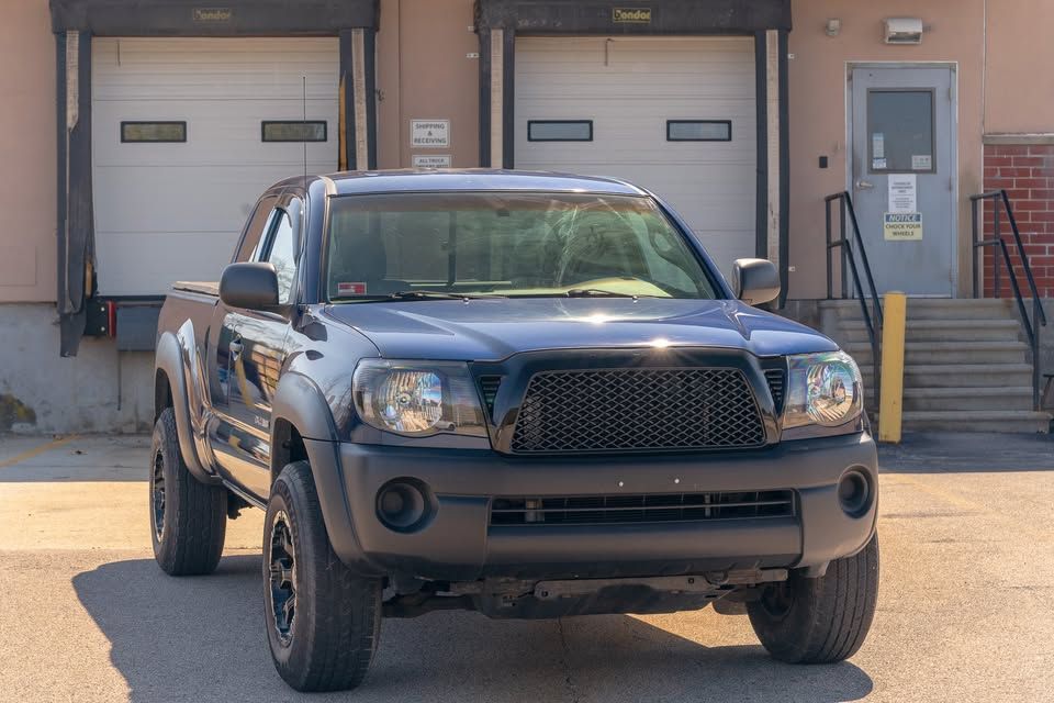 A black truck is parked in front of a garage door.