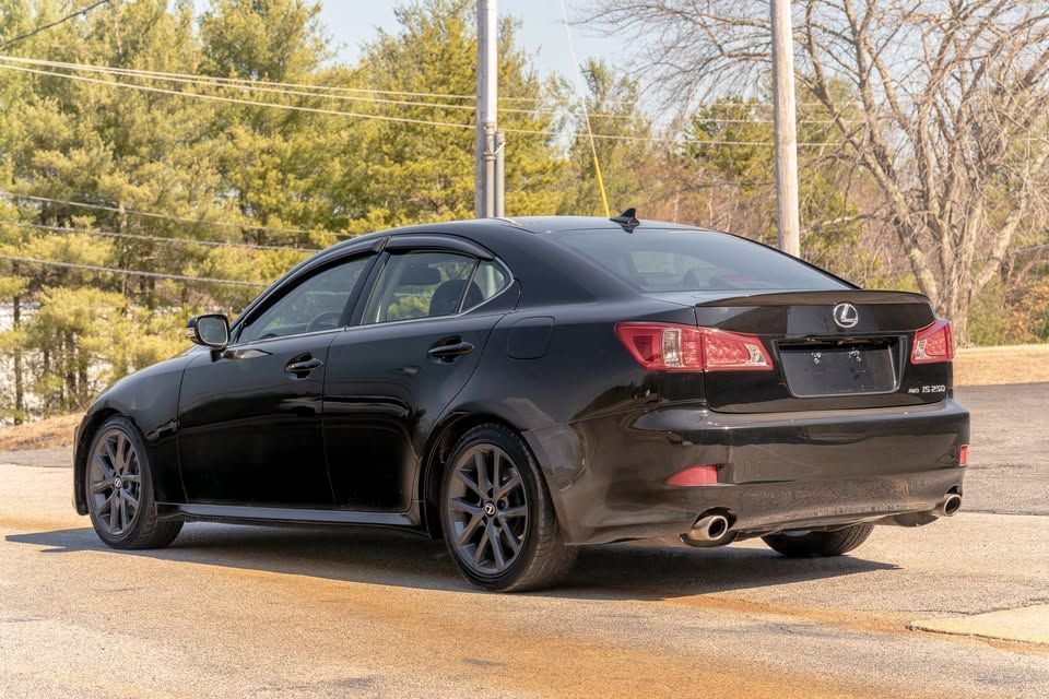 A black lexus is250 is parked in a parking lot.