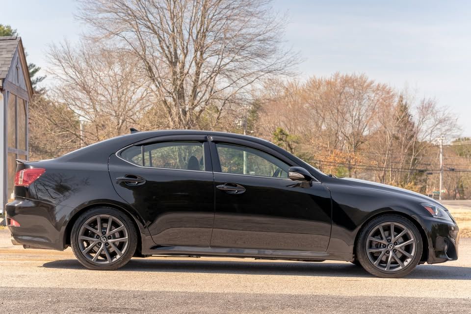 A black car is parked on the side of the road.