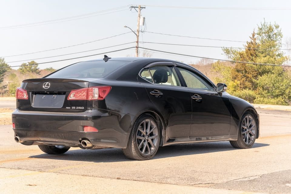 A black lexus is250 is parked in a parking lot.
