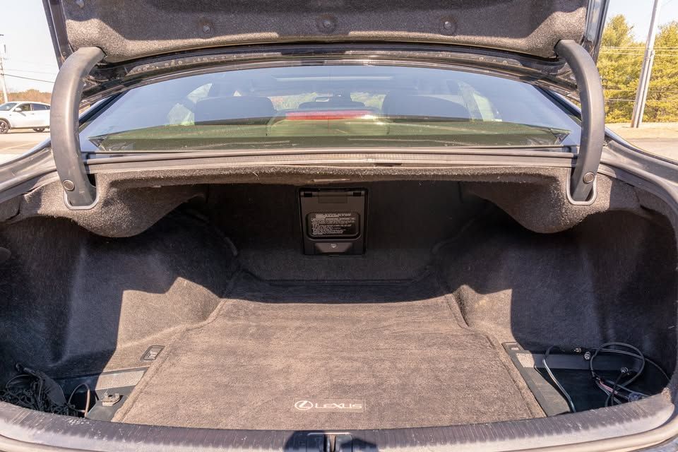 The trunk of a black lexus is open and empty.