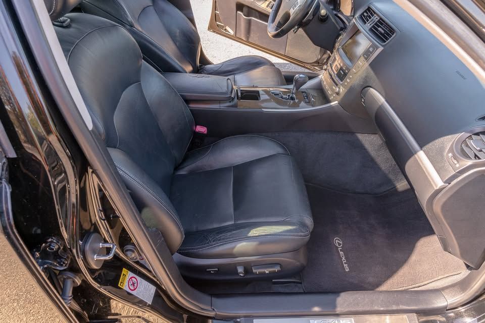 The interior of a black lexus car with the door open.