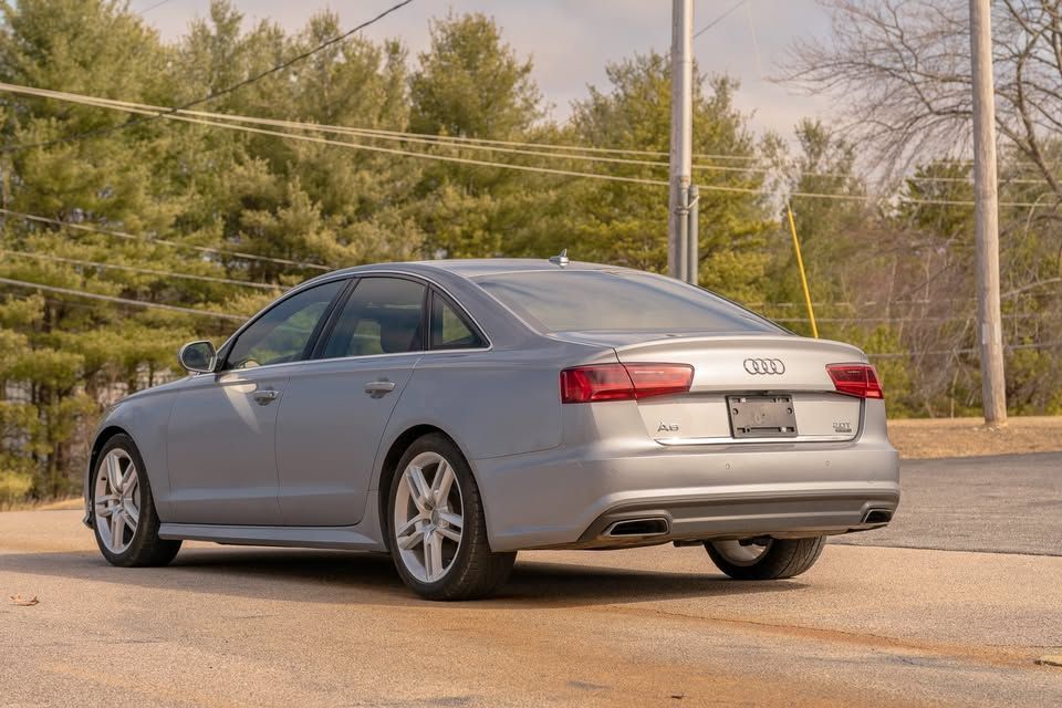 A silver audi a6 is parked in a parking lot.