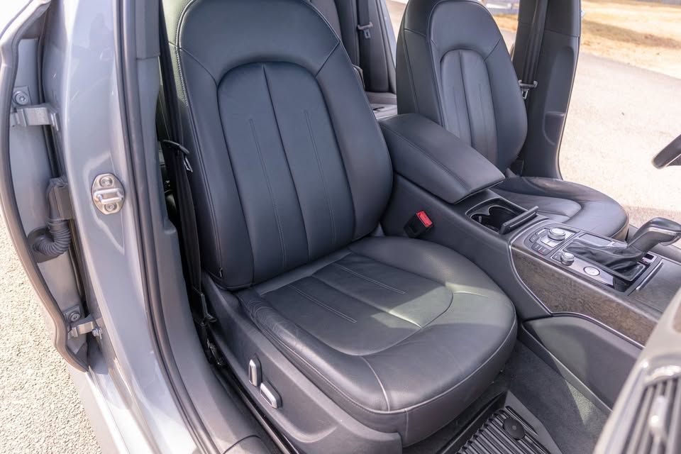 A car with black leather seats is parked on the side of the road.