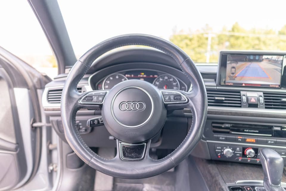 A close up of the steering wheel and dashboard of a car.