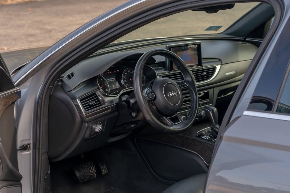The interior of a car with the door open and the steering wheel visible.