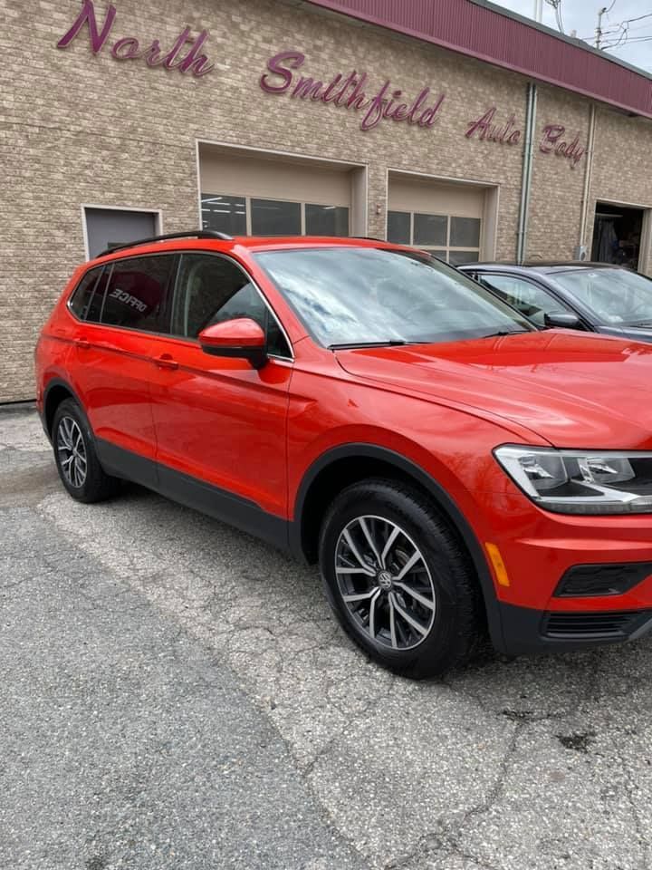 A red vehicle is parked in front of the North Smithfield Auto Body Inc building