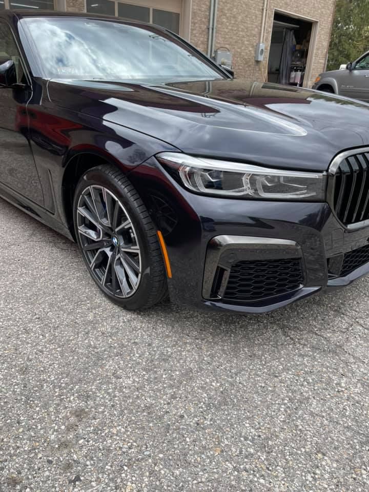 A close up of a black vehicle's right headlight and tire