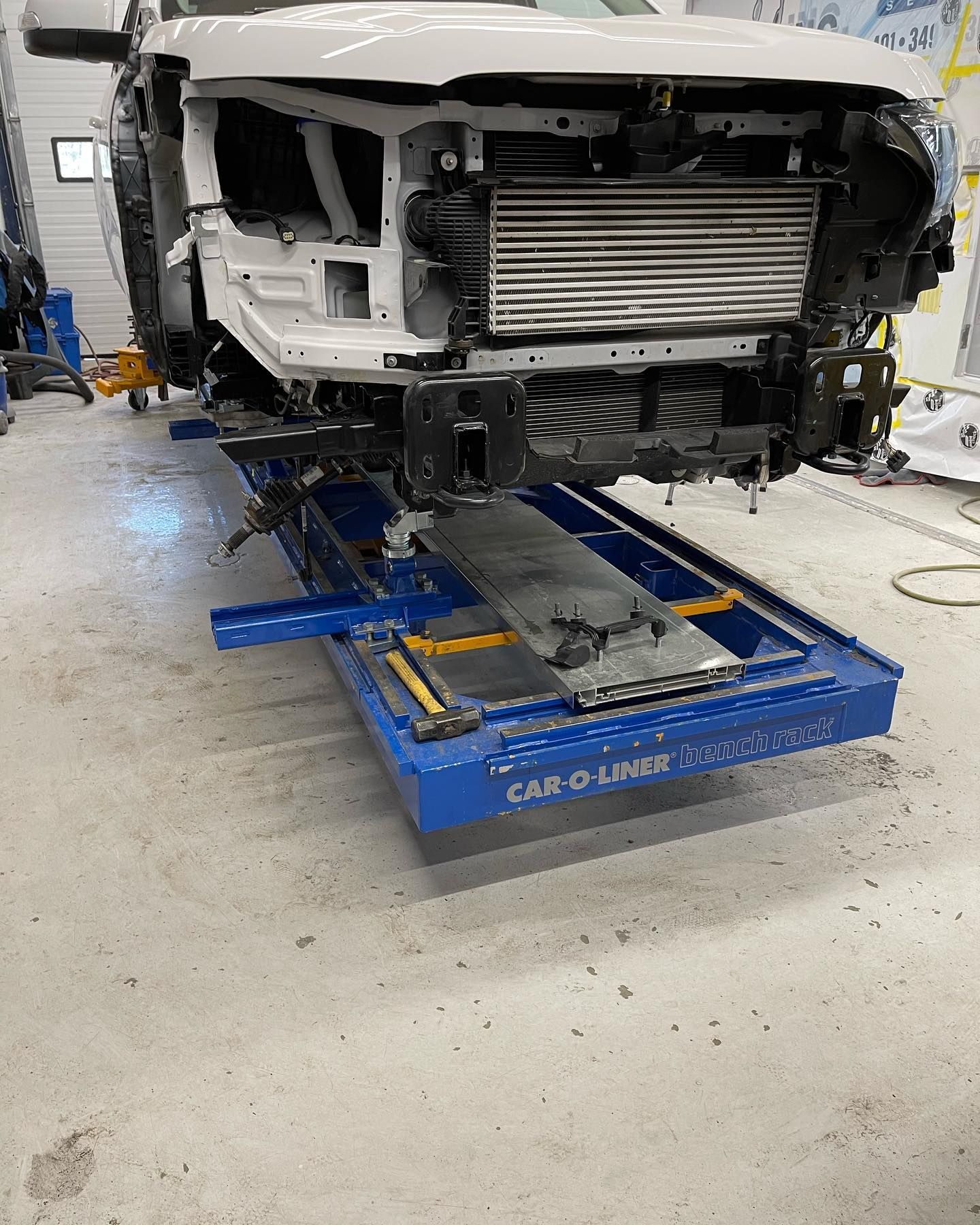 A car is sitting on a lift in an auto body shop