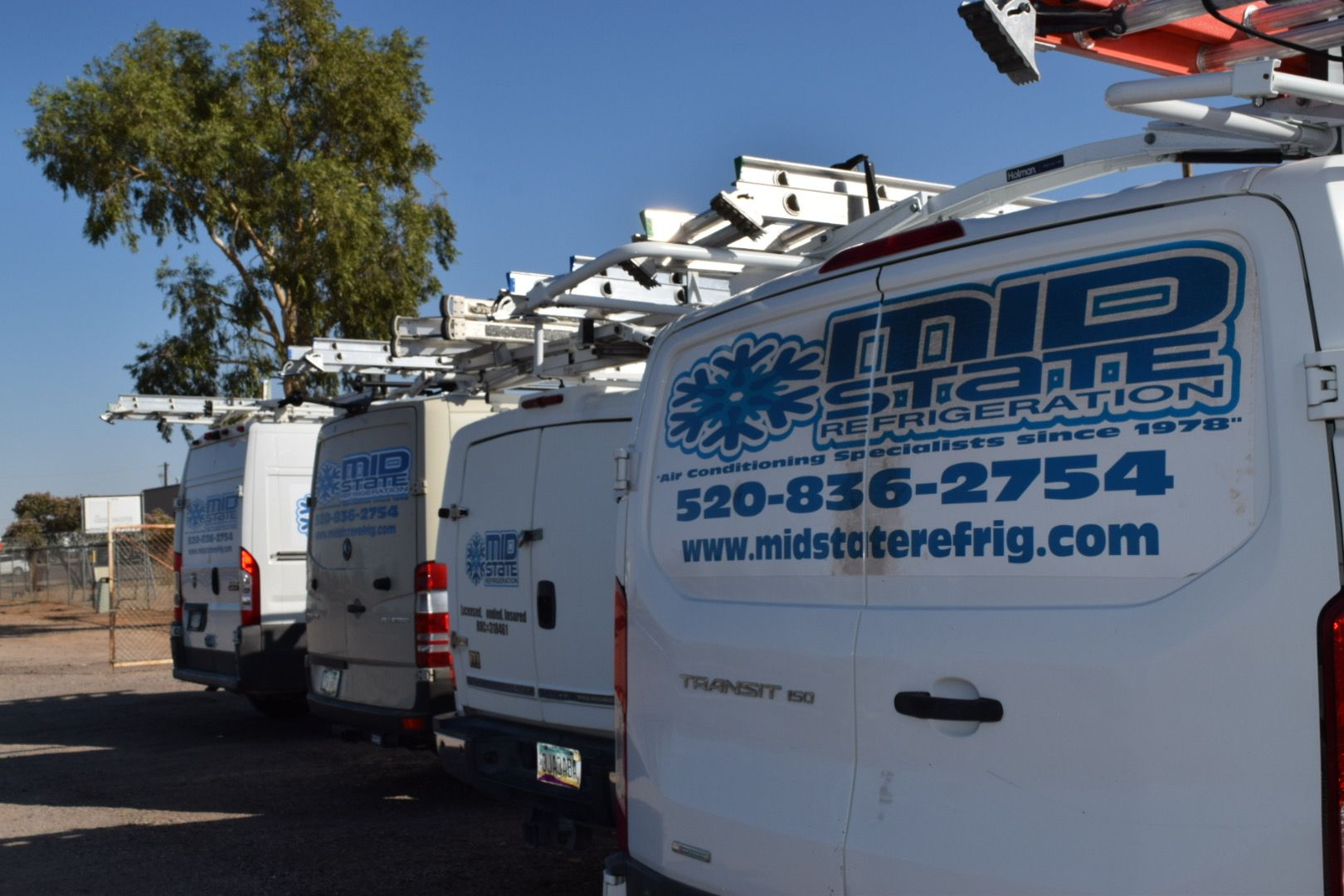 A man is fixing an air conditioner with a screwdriver.