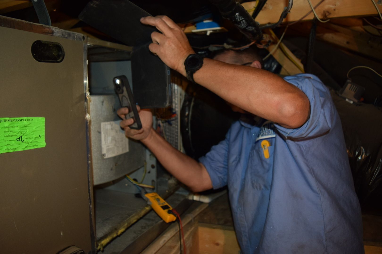 An air conditioner is sitting on a pile of rocks next to a house.