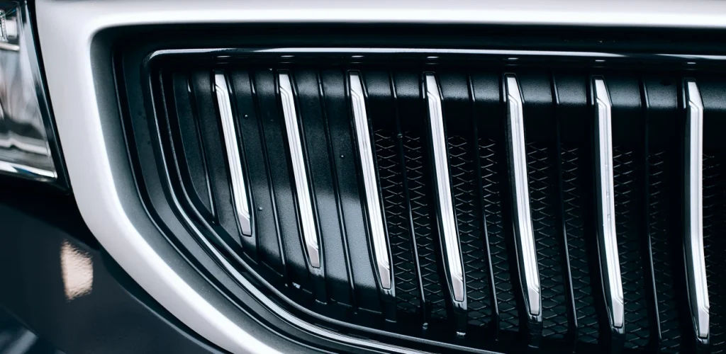 Close-up of a car grille with chrome vertical slats and black accents