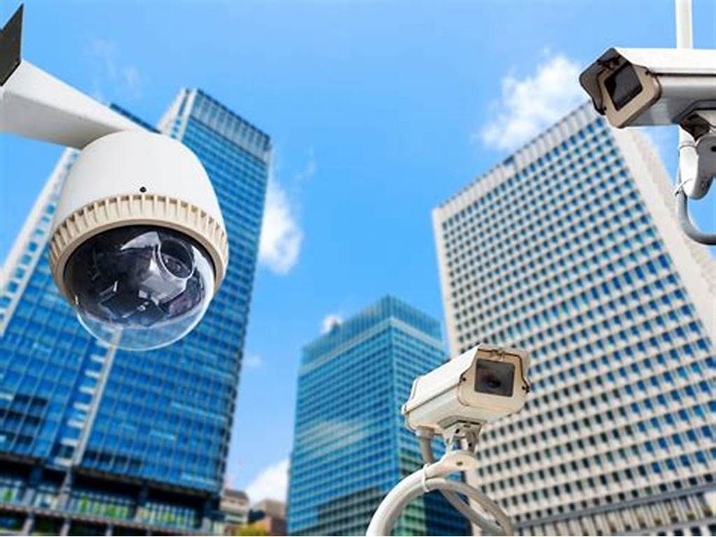 City surveillance cameras overlooking modern office skyscrapers under a blue sky