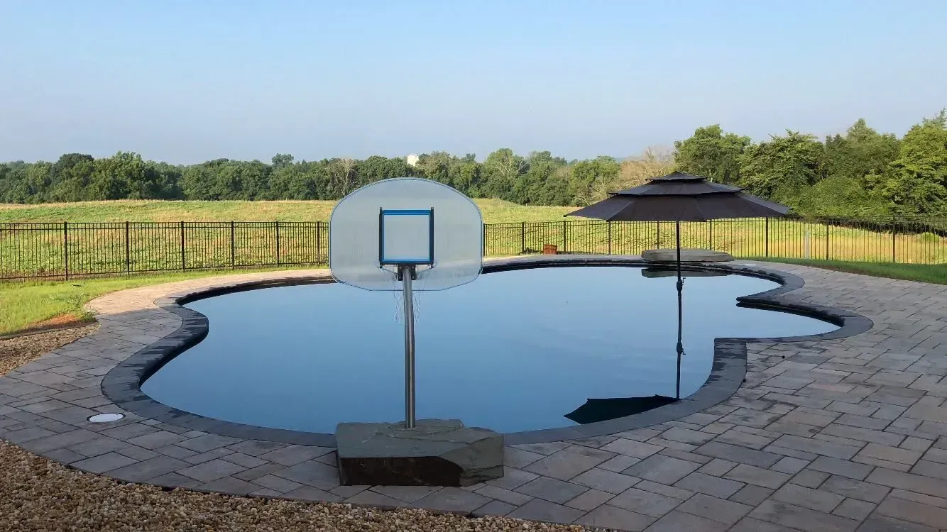 A basketball hoop is in the middle of a swimming pool.