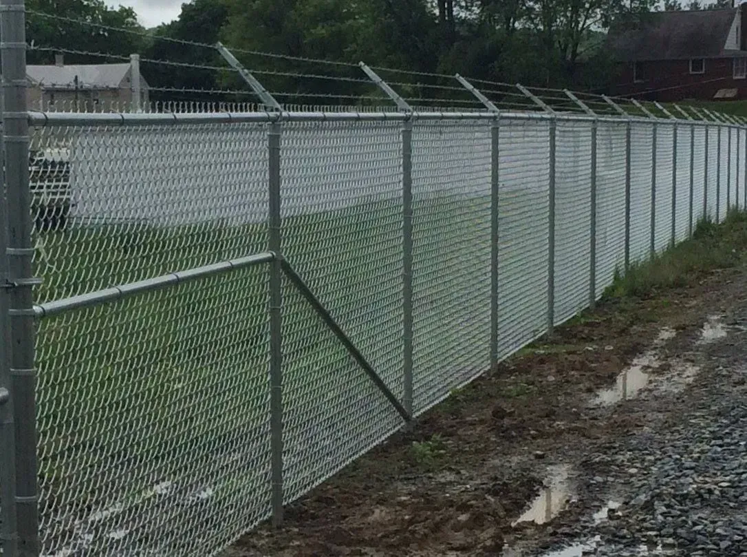 A chain link fence with barbed wire on top of it.