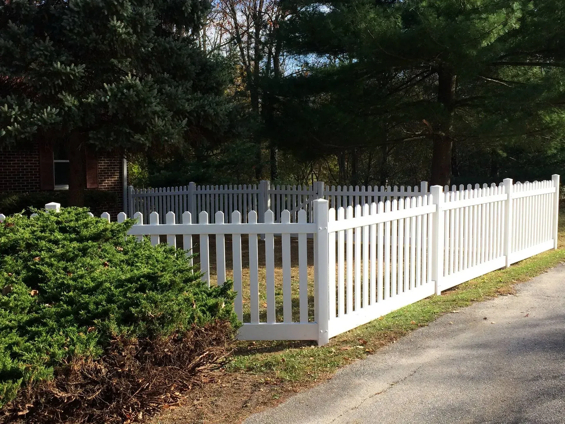 A white picket fence along the side of a road