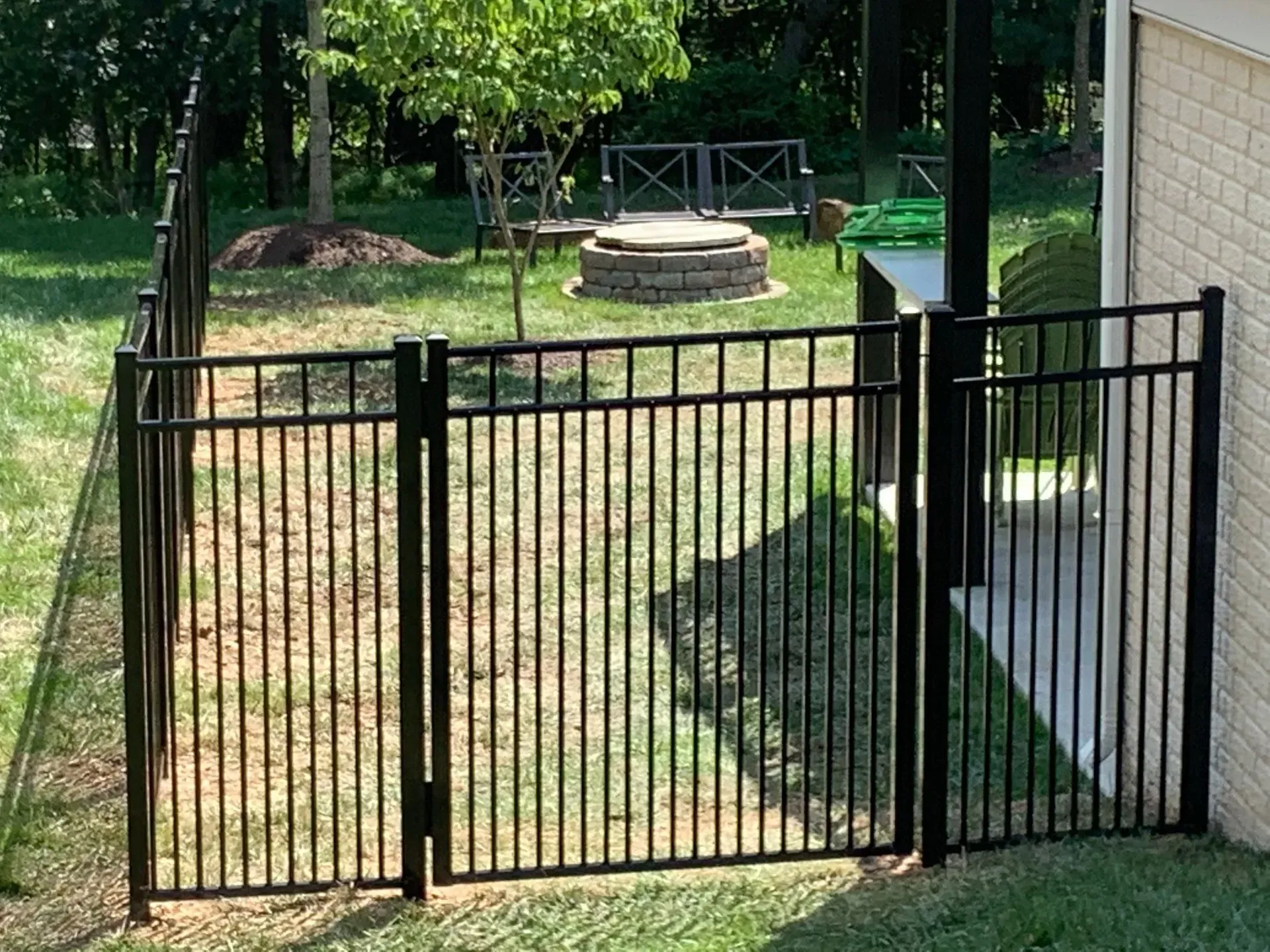 There is a fire pit in the backyard behind the fence.