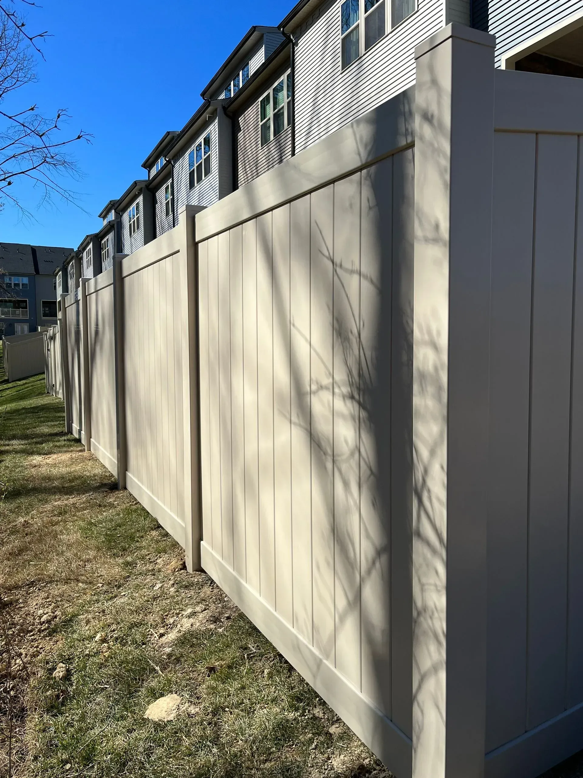 A white fence is sitting in front of a row of houses.