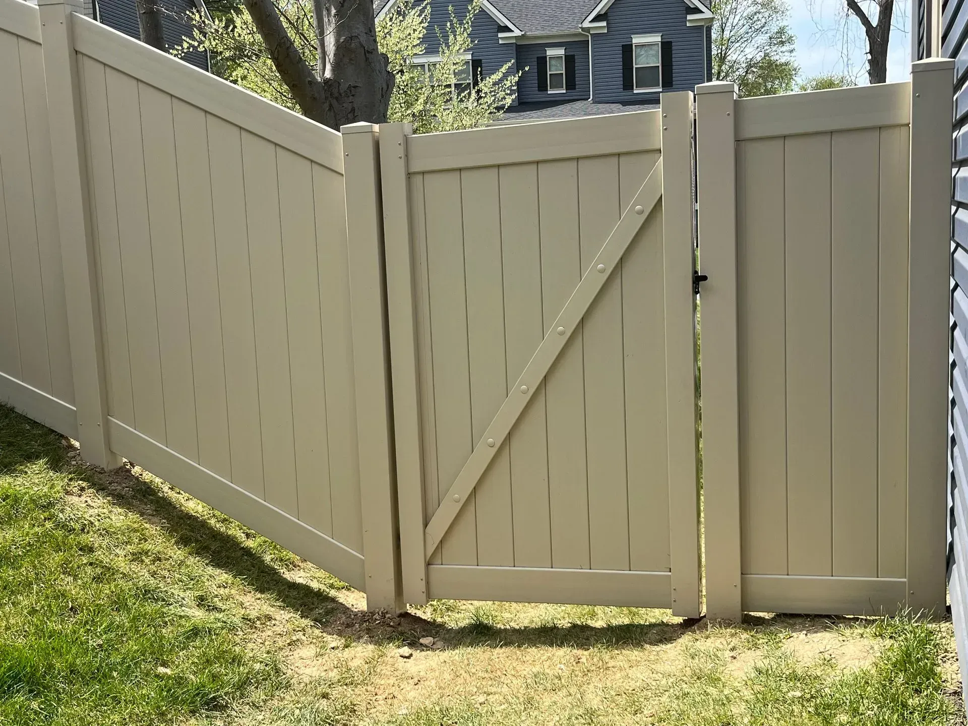 A white fence with a gate in the middle of it