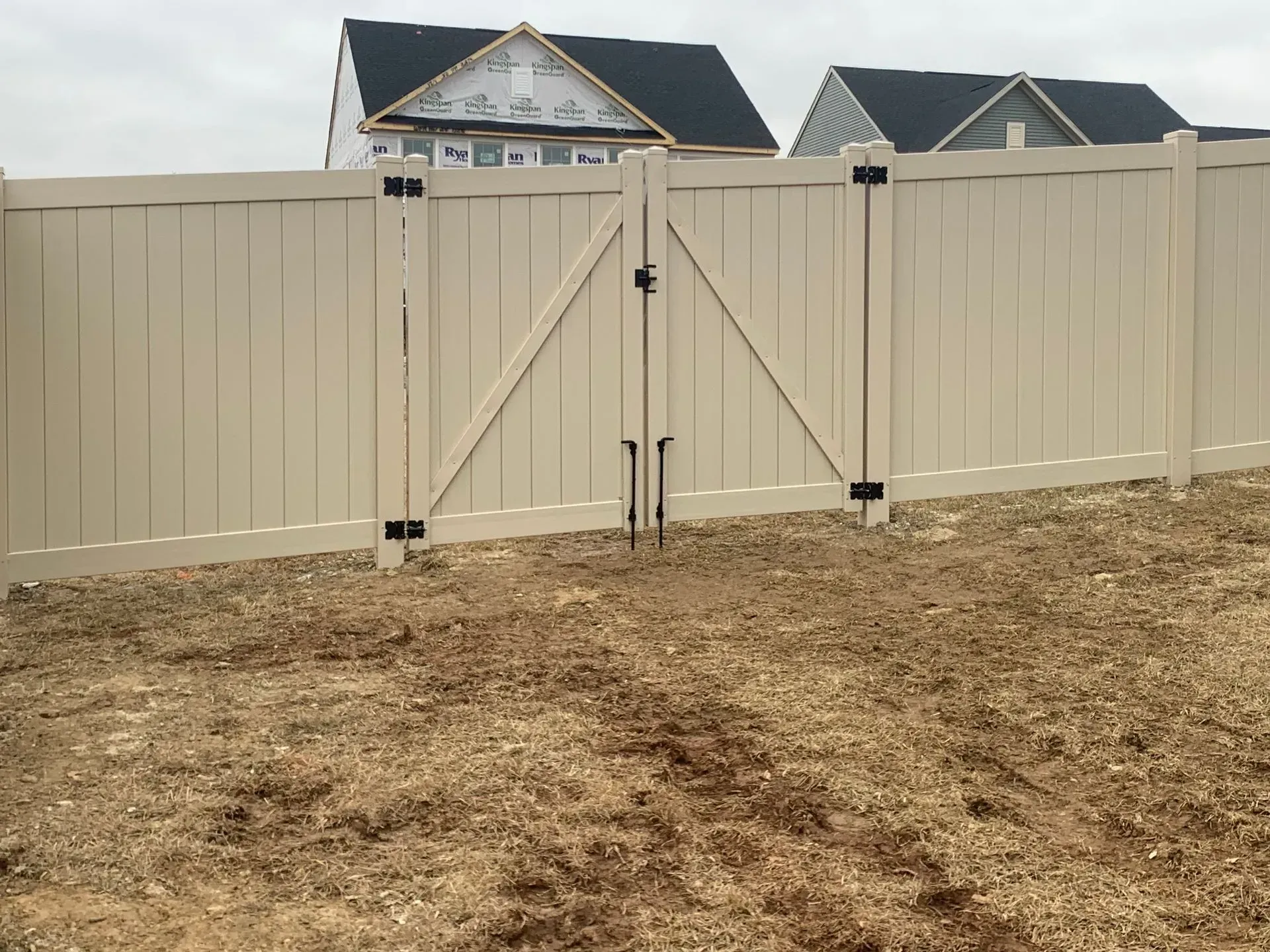 A white fence with a gate in front of a house.