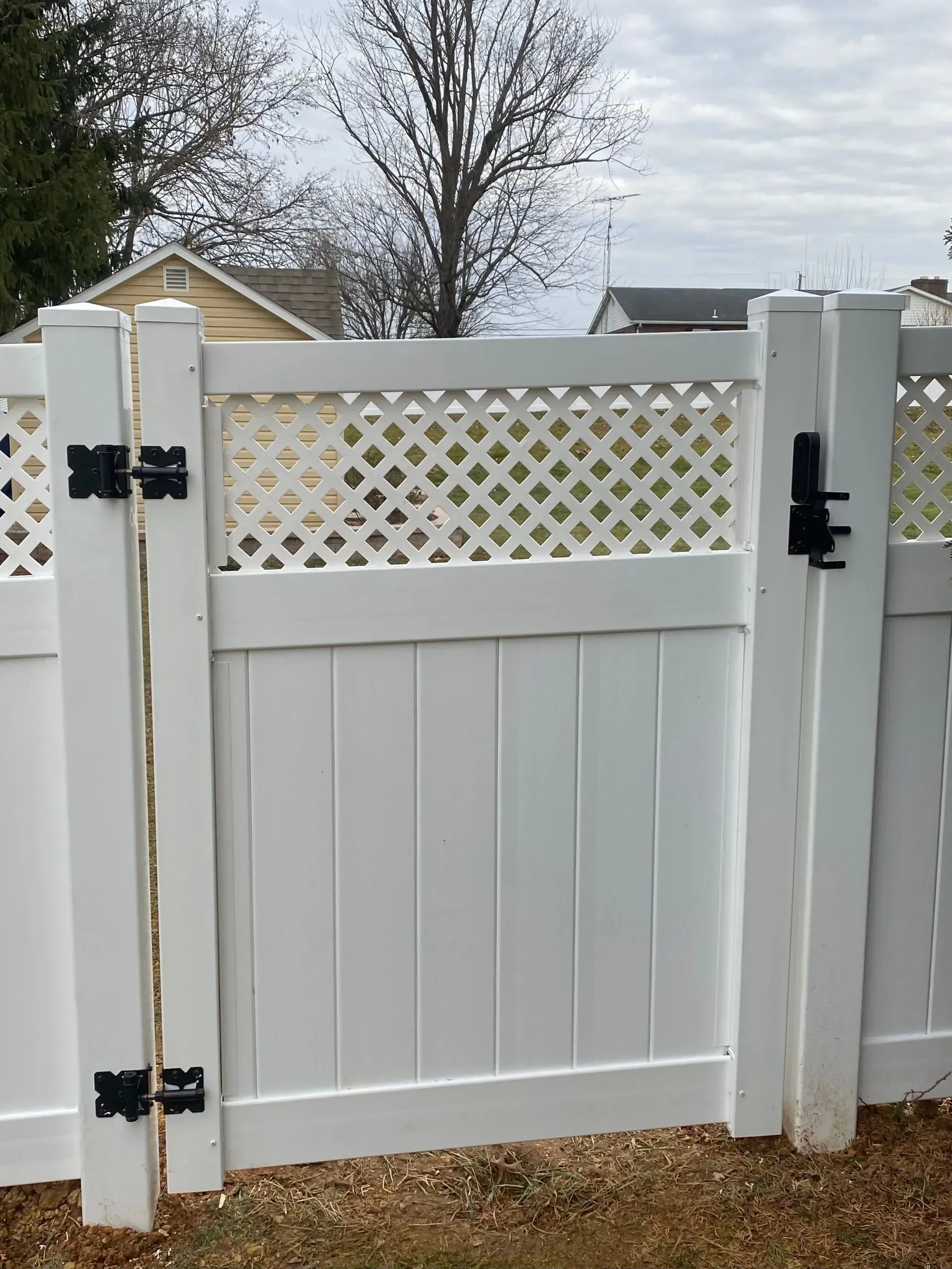 A white fence with a gate attached to it.