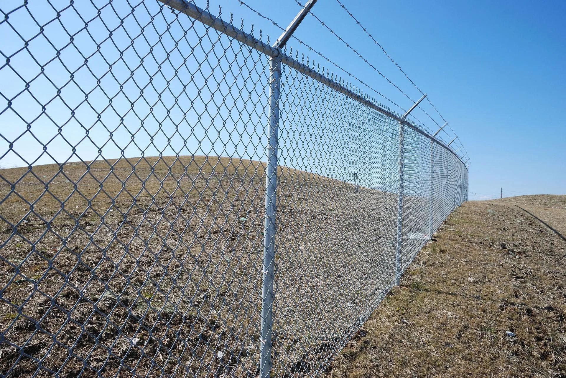 A chain link fence with barbed wire on top of it