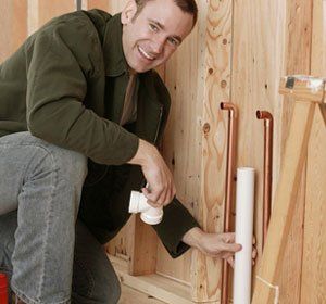 male plumber installing pvc pipe
