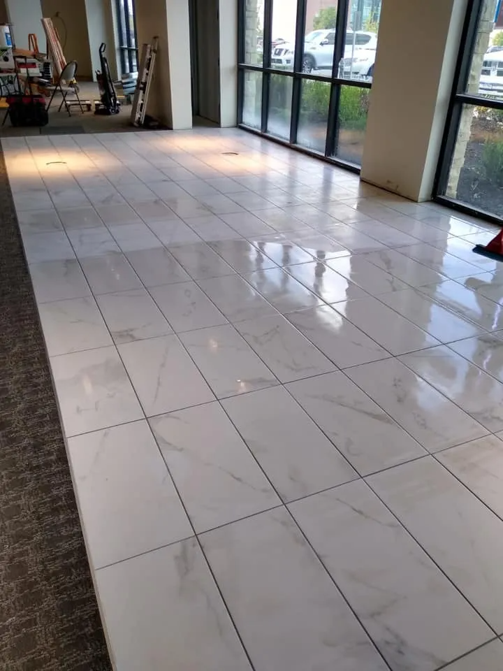 White marble tile floor in a building with large windows.