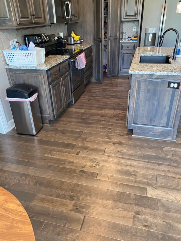 Kitchen with wood floors, cabinets, countertops, and stainless steel appliances.