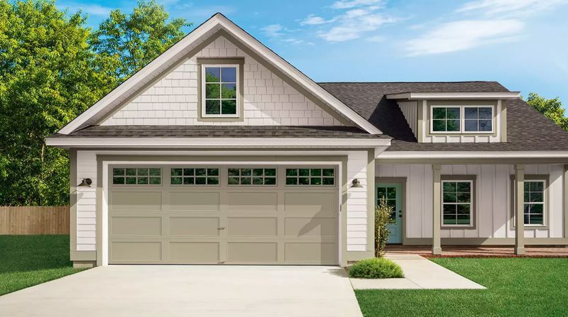 Suburban beige house with attached garage, white trim, and a green lawn under a blue sky
