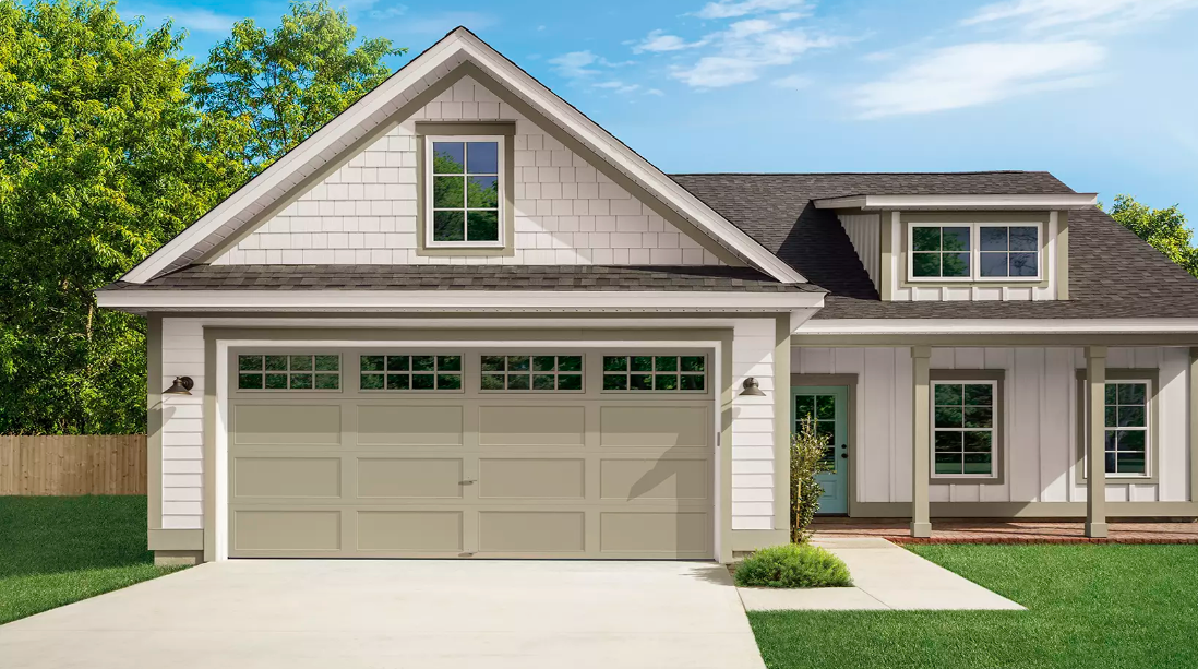 Suburban house with beige siding, two-car garage, and manicured lawn under a blue sky
