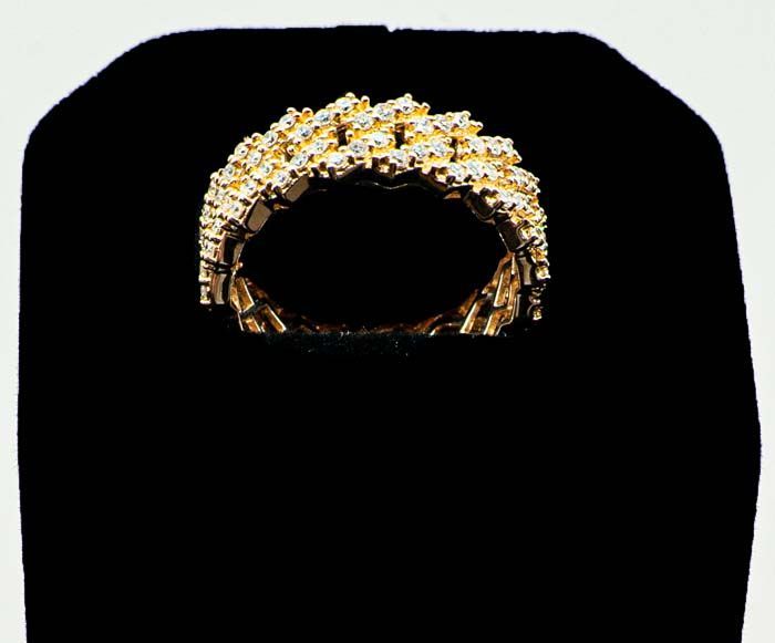 Gold and white ornate ring-shaped crown or bracelet centered on a black background